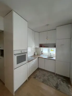 a white kitchen with white cabinets and a sink at Ana’s 2 bedrooms lovely flat in Podgorica