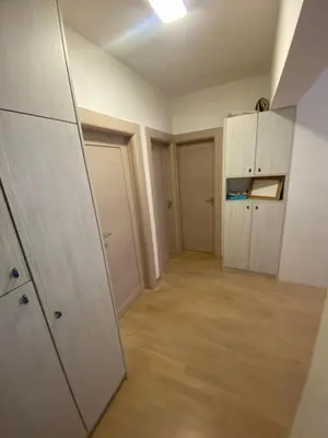 an empty room with white doors and wooden floors at Ana’s 2 bedrooms lovely flat in Podgorica