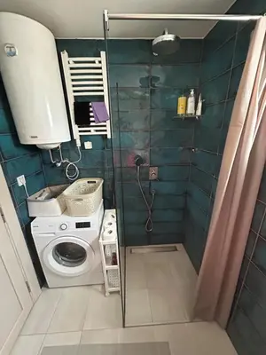 a bathroom with a shower and a washing machine at Ana’s 2 bedrooms lovely flat in Podgorica