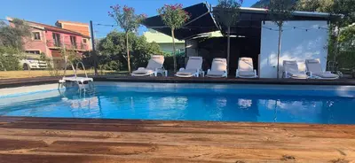 a swimming pool with white chairs and a group at Owl's Nest in Bar