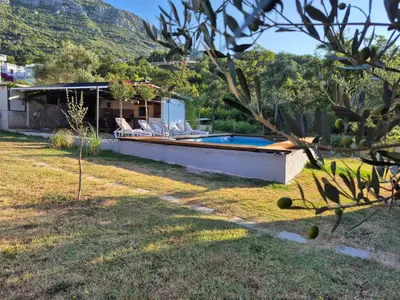 a backyard with a swimming pool and a house at Owl's Nest in Bar