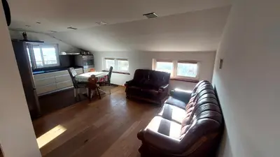 a living room with a leather couch and a table at Owl's Nest in Bar
