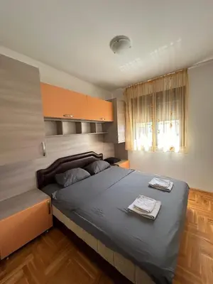 a bedroom with a large bed and a window at Apartment Pegaz in Budva