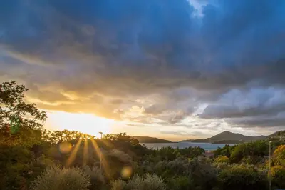 a view of the sun setting over the water at Lux apartment Amarin in Pržno