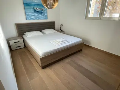 a bedroom with a bed with a wooden floor at Lux apartment Amarin in Pržno