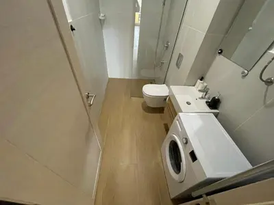 a white bathroom with a toilet and a sink at Lux apartment Amarin in Pržno