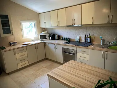 a kitchen with white cabinets and a counter top at Captivating and Spacious 2-Bed House in Vranovici in Drakulovići