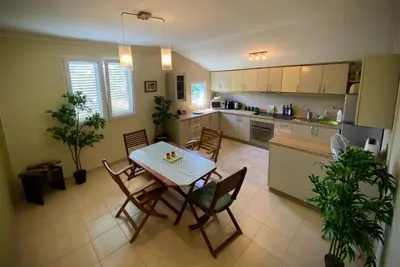 a kitchen and dining room with a table and chairs at Captivating and Spacious 2-Bed House in Vranovici in Drakulovići