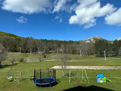 an empty park with two swings and a trampoline at Hotel Monte Rosa in Cetinje