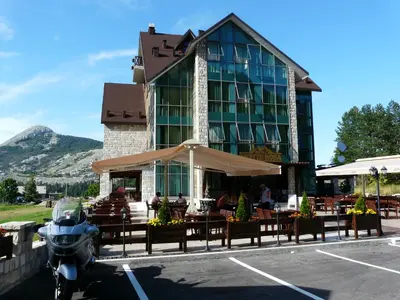 a motorcycle parked in a parking lot in front of a building at Hotel Monte Rosa in Cetinje