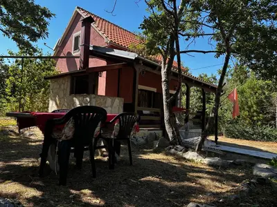 a table and chairs in front of a house at Holiday Home Nikolić in Njeguši