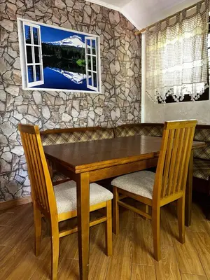 a wooden table with two chairs and a stone wall at Holiday Home Nikolić in Njeguši