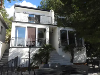 a white house with stairs and a balcony at Digital Nomads Apartments in Bar