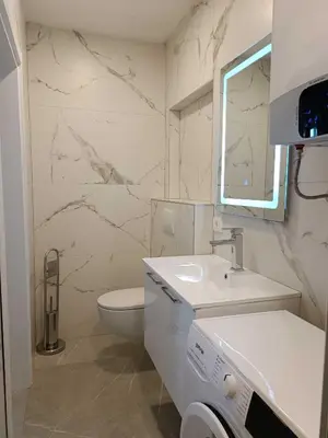 a white bathroom with a sink and a toilet at Digital Nomads Apartments in Bar