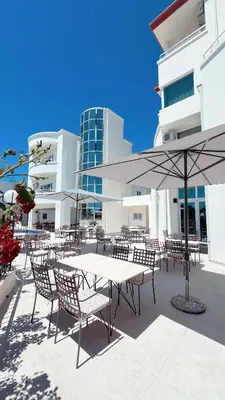 a table and chairs with umbrellas in front of a building at Imperial Hotel in Ulcinj