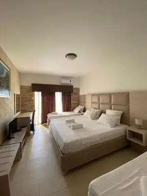 a hotel room with two beds and a television at Imperial Hotel in Ulcinj