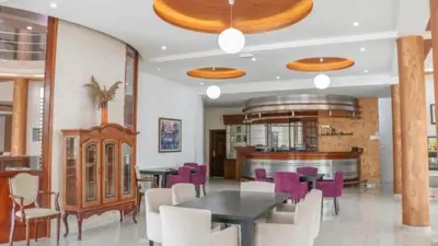 a dining room with a table and purple chairs at Imperial Hotel in Ulcinj