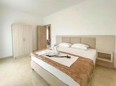 a bedroom with a large white bed with a towel on it at Imperial Hotel in Ulcinj
