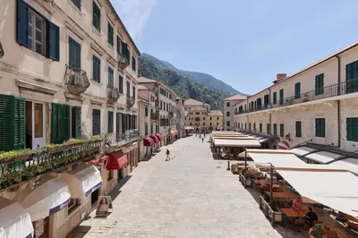 a city street with tables and umbrellas and buildings at Spacious 1Bedroom on the Main Square of Kotor in Kotor