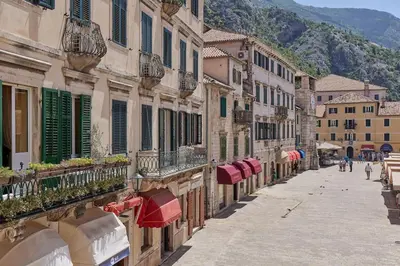 an empty street with buildings and umbrellas in a city at Spacious 1Bedroom on the Main Square of Kotor in Kotor