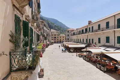 a street with buildings and tables and umbrellas at Spacious 1Bedroom on the Main Square of Kotor in Kotor