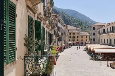 a city street with buildings and green shutters at Spacious 1Bedroom on the Main Square of Kotor in Kotor