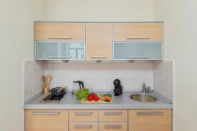 a kitchen with wooden cabinets and a sink at Spacious 1Bedroom on the Main Square of Kotor in Kotor