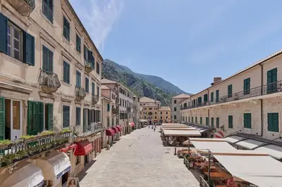 a street with tables and umbrellas in an alley at Spacious 1Bedroom on the Main Square of Kotor in Kotor