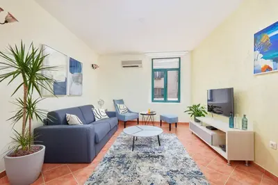 a living room with a blue couch and a tv at 1-Bedroom Flat on the Main Square in the Old Town in Kotor