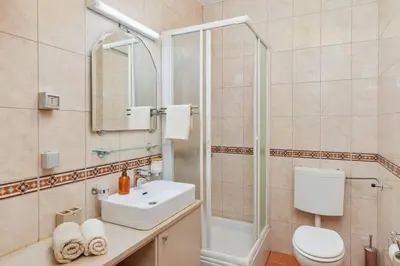 a bathroom with a sink and a shower and a toilet at 1-Bedroom Flat on the Main Square in the Old Town in Kotor