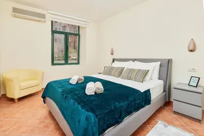 a bedroom with a bed with two slippers on it at 1-Bedroom Flat on the Main Square in the Old Town in Kotor