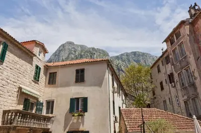 an alley with buildings and mountains in the background at Well Located 1Bedroom in the Heart of the Old Town in Kotor