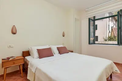 a white bed in a room with a window at Well Located 1Bedroom in the Heart of the Old Town in Kotor