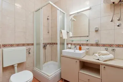 a bathroom with a shower and a toilet and a sink at Well Located 1Bedroom in the Heart of the Old Town in Kotor