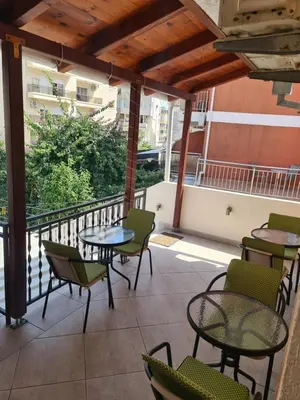 a patio with tables and chairs on a balcony at Sobe Nedović in Budva