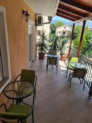 a patio with tables and chairs on a balcony at Sobe Nedović in Budva