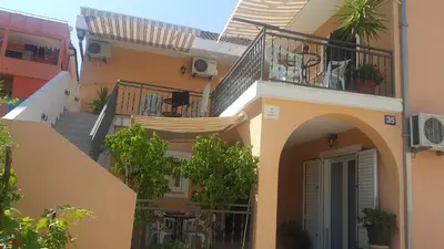 an apartment building with stairs and a balcony at Sobe Nedović in Budva