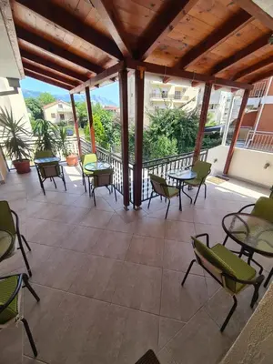 a patio with tables and chairs on a balcony at Sobe Nedović in Budva