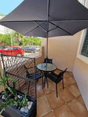 a table and chairs under an umbrella on a patio at Guest House Damjana in Budva