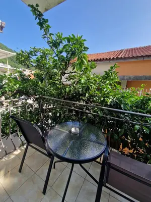 a glass table and a chair on a balcony at Guest House Damjana in Budva