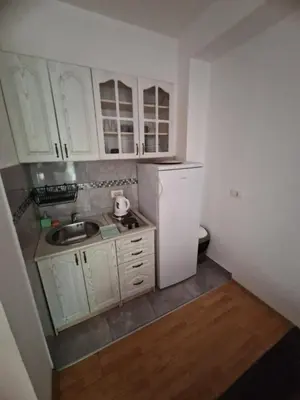 a small kitchen with white cabinets and a sink at Guest House Damjana in Budva