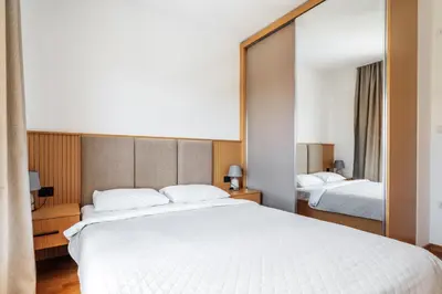a bedroom with a large white bed and a mirror at Status-M Apartments 103 in Becici