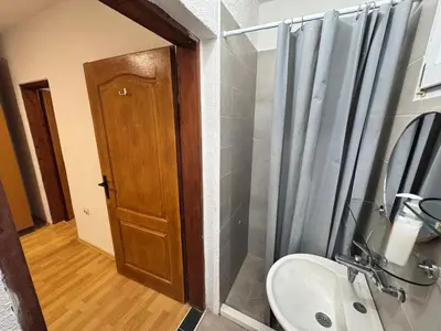 a bathroom with a sink and a wooden door at Mon in Bar