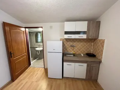 a small kitchen with a refrigerator and a sink at Mon in Bar