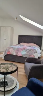 a bedroom with a bed and a table and a couch at Naki home in Pobrežje
