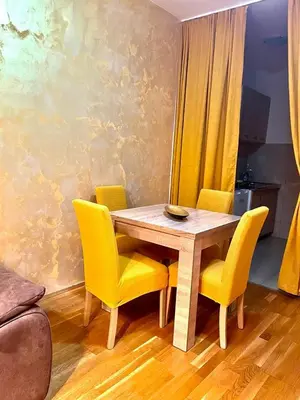 a dining room table and chairs with yellow chairs at Naki home in Pobrežje