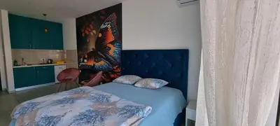 a bedroom with a bed with a blue head board at Naki home in Pobrežje