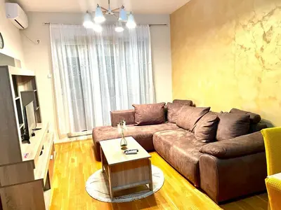 a living room with a brown couch and a table at Naki home in Pobrežje