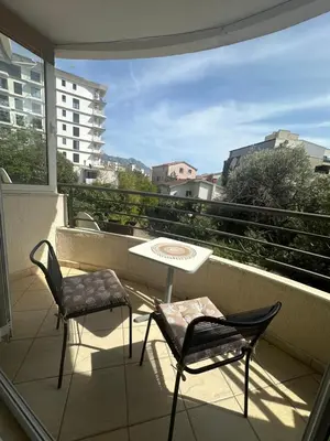 a patio with two chairs and a table on a balcony at Budva - Becici in Becici