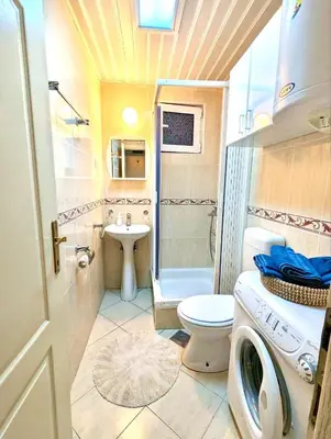 a bathroom with a toilet and a sink and a washing machine at Budva - Becici in Becici
